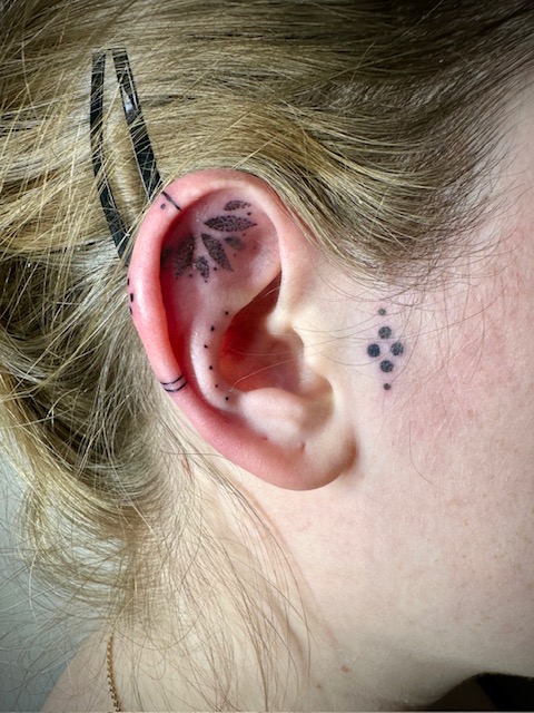 Tatouage fine line miniature sur l'oreille
